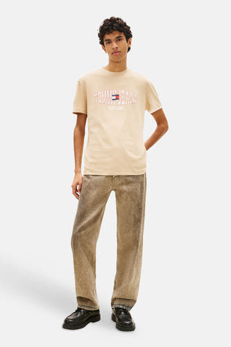 Beige T-shirt van TOMMY JEANS met rood omrand logo en opschrift op de borst.