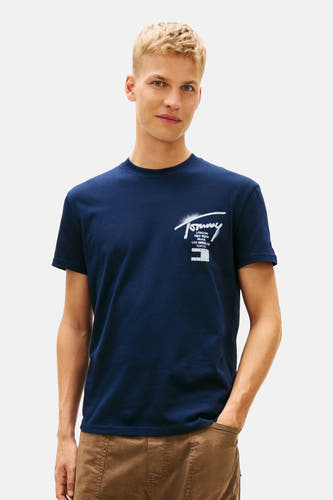 Blauw T-shirt met korte mouwen van TOMMY JEANS, met witte logo-opdruk op de borst, gedragen met een bruine broek.