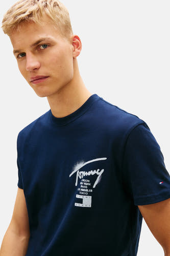 Blauw T-shirt met korte mouwen van Tommy Jeans, met een logo en diverse namen van steden op de voorkant.
