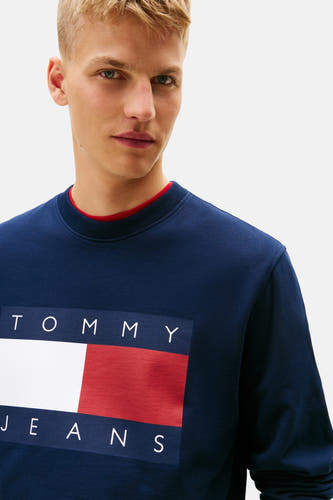 Blauw sweatshirt van TOMMY JEANS met groot logo op de borst en rode ronde hals.
