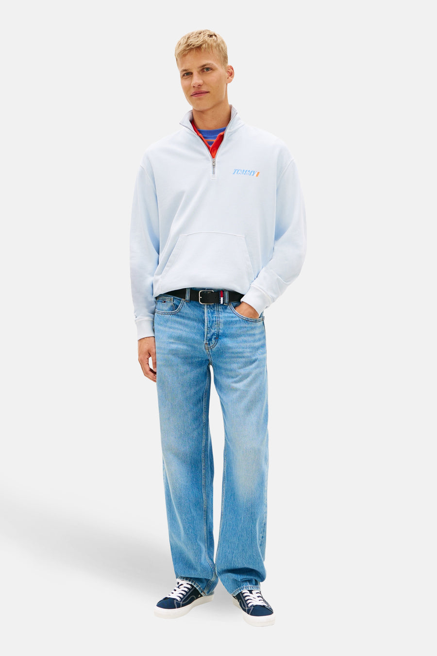Blauwe sweater met rolkraag van Tommy Jeans, met een korte rits en losse pasvorm over een rode top.