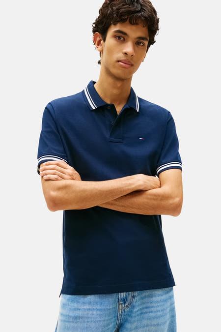 Blauwe polo met korte mouwen van Tommy Jeans, met witte strepen op de kraag en mouwen.