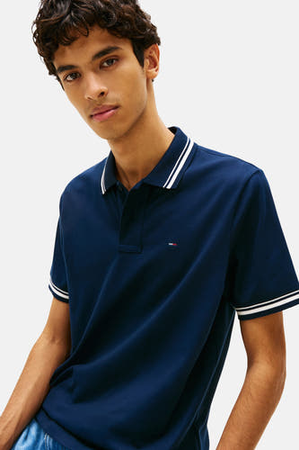 Blauwe polo met korte mouwen van TOMMY JEANS, met witte strepen langs de kraag en mouwen.