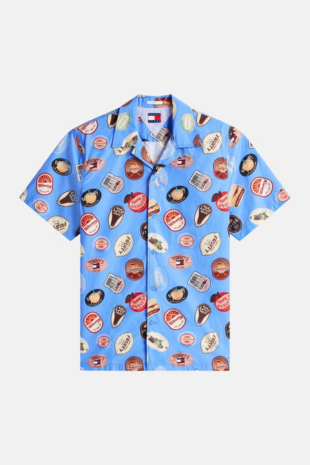 Blauw overhemd met korte mouwen van TOMMY JEANS, voorzien van een patroon met fruitsticker-achtige afbeeldingen.
