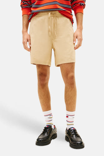Lichtbruine short met trekkoord van TOMMY JEANS, gestyled met een gestreept shirt en zwarte platform schoenen.