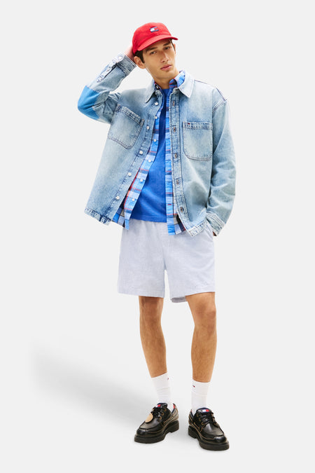 Lichtblauwe short van TOMMY JEANS met fijne strepentextuur, gecombineerd met een denim jack en T-shirt.