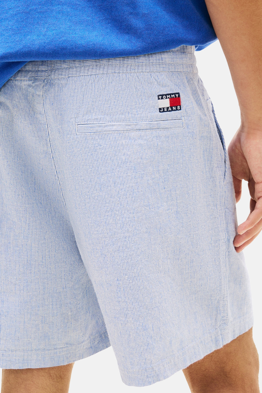 Short bleu TOMMY JEANS à fines rayures verticales, taille élastique, poche passepoilée et écusson logo à l'arrière.