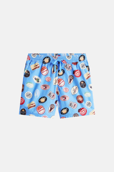 Blauwe short van TOMMY JEANS met een all-over print van fruitsticker-achtige logo's.
