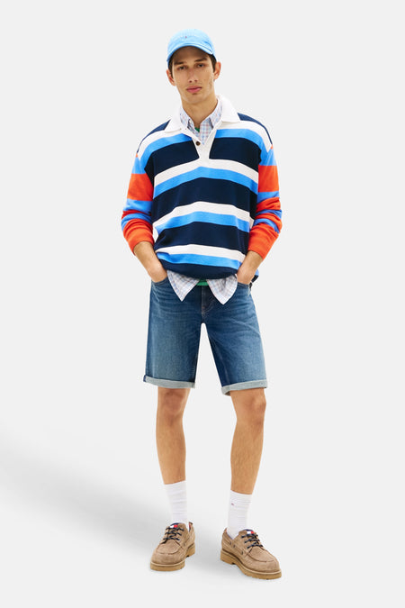 Donkerblauwe denim jeansshort van TOMMY JEANS met opgerolde zomen, gedragen door een man.