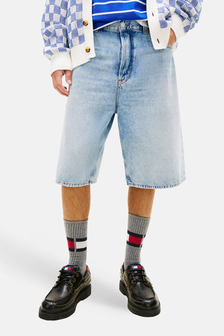 Jeansshort van blauw denim van TOMMY JEANS, met Tommy Hilfiger sokken en zwarte leren schoenen.