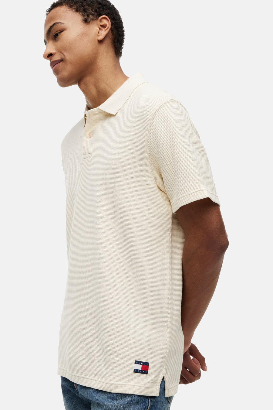 Ecru polo met ribstructuur van TOMMY JEANS, zijaanzicht met logo patch aan de zoom