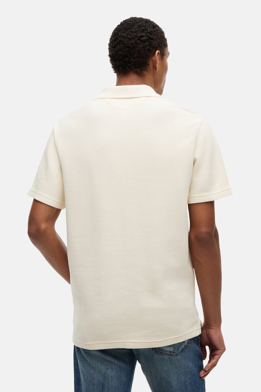 Ecru polo met ribstructuur van TOMMY JEANS, achterzijde, model draagt blauwe jeans