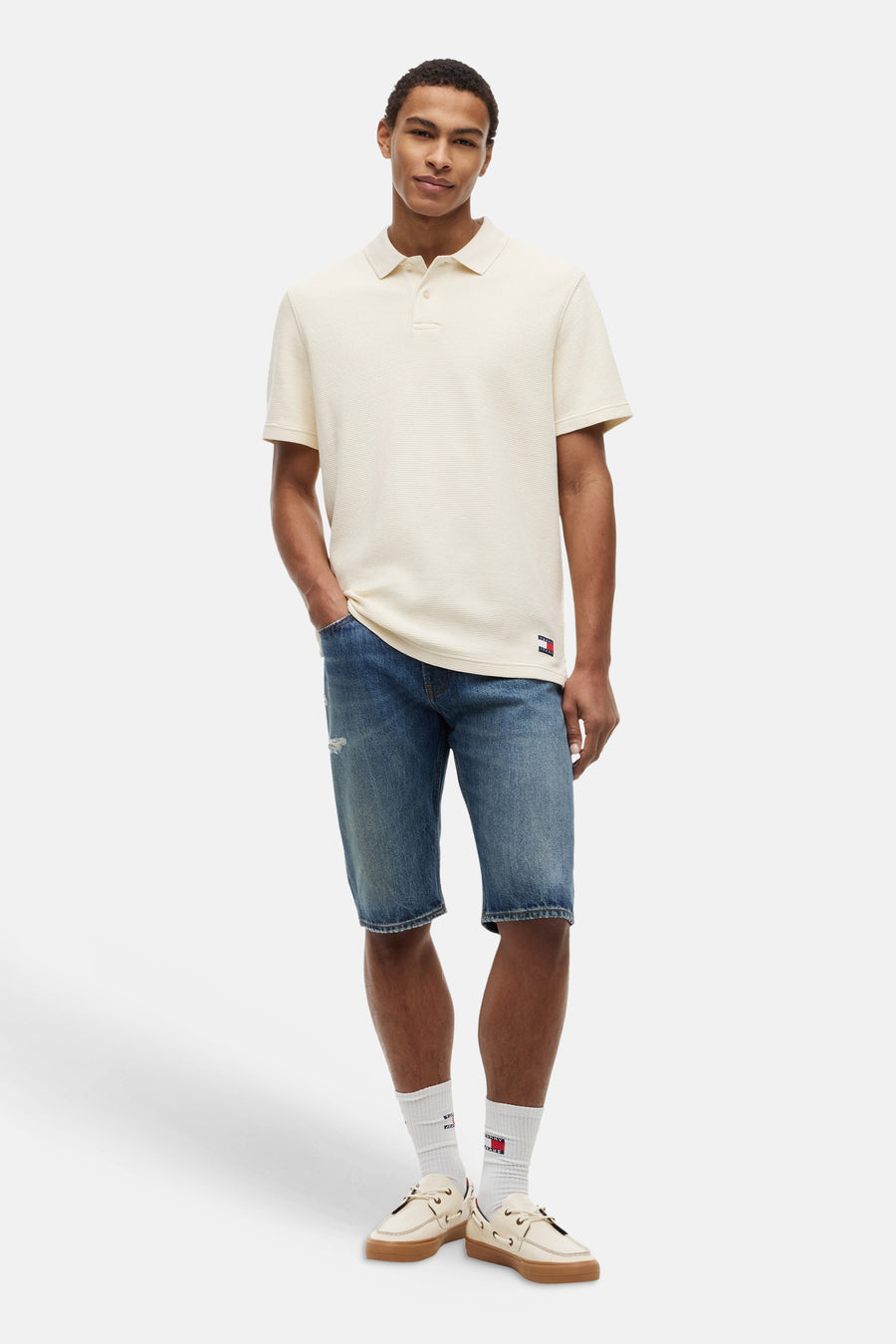 Ecru polo met textuur van TOMMY JEANS, vooraanzicht, model draagt blauwe denim shorts en witte sneakers