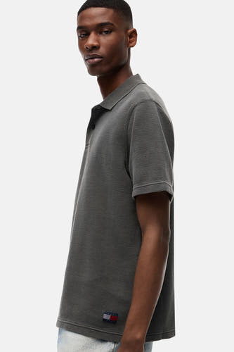 Zwart polo met ribstructuur van TOMMY JEANS, zijaanzicht met logo-patch op borst, casual fit
