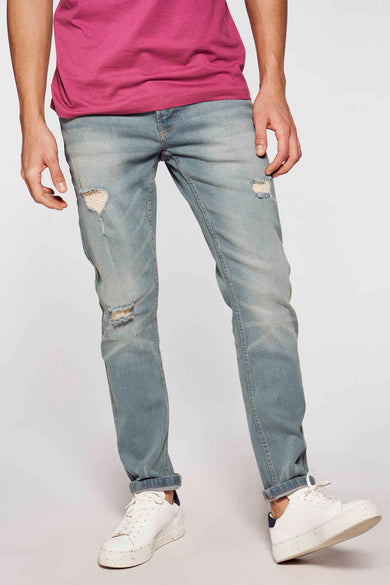 Slim jeans van lichtblauw denim van DENIM PROJECT, met scheuren en opgerolde pijpen, gecombineerd met een roze T-shirt en witte sneakers.
