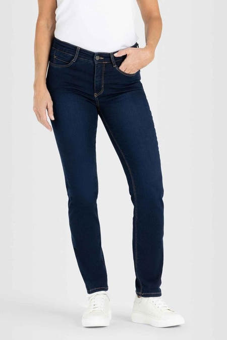 Donkerblauwe straight jeans van MAC, met contrasterende stiksels, gecombineerd met een wit shirt en witte schoenen.