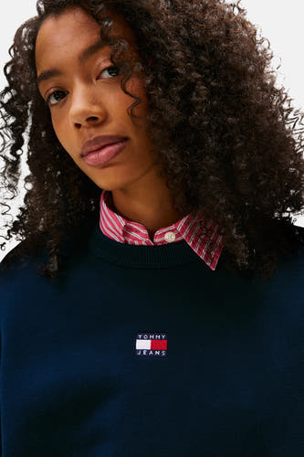 Blauwe sweater van TOMMY JEANS, met een overhemd met rood streepjesdessin en een logo op de borst.

