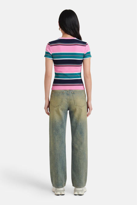 Multicolor gestreepte korte mouwen T-shirt van TOMMY JEANS, achterzijde weergegeven, met roze, marineblauw en turkoois, gedragen met groene jeans en witte sneakers