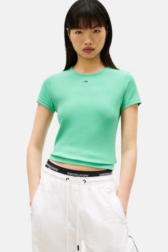 Groen T-shirt met korte mouwen van TOMMY JEANS, met ribstructuur, gedragen met witte joggingbroek met Tommy Jeans-band.