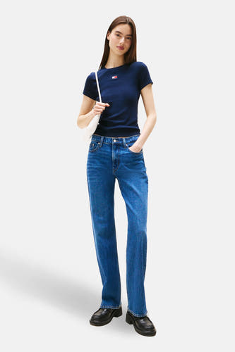 Blauw T-shirt met korte mouwen van TOMMY JEANS, met een klein logo en gecombineerd met jeans en zwarte schoenen.
