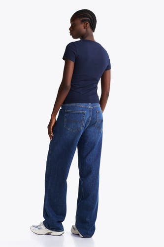 Blauw T-shirt met korte mouwen van TOMMY JEANS, met rechte jeans en sneakers.
