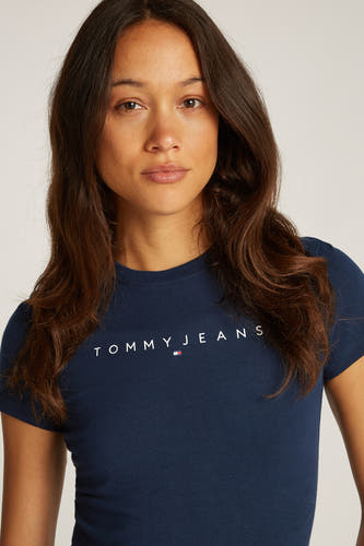 Blauw T-shirt met korte mouwen van TOMMY JEANS, gedragen door een vrouw met losse, bruine haren.