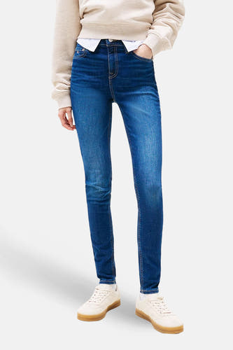 Skinny jeans van donkerblauw denim van TOMMY JEANS, met een casual sweater en sneakers.
