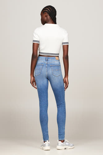 Skinny jeans van blauw denim van Tommy Jeans, met een aansluitende pasvorm en zilverkleurige sneakers.
