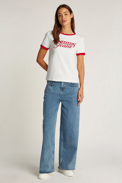 Wit T-shirt met korte mouwen van Tommy Jeans, afgewerkt met rode biezen langs de hals en mouwen, gedragen met wijde jeans.