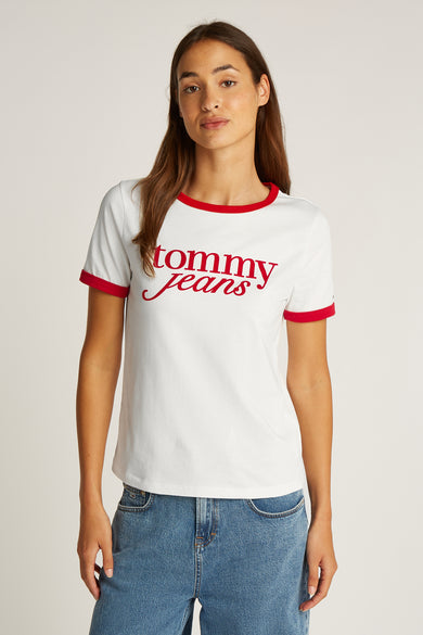 Wit T-shirt met korte mouwen van TOMMY JEANS, met rode bies en bijpassende tekst. Gedragen met blauwe jeans.