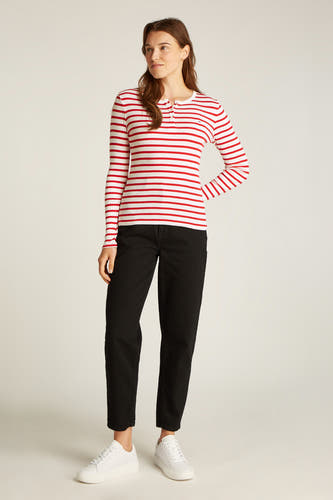 Rood gestreept T-shirt met lange mouwen van TOMMY JEANS, met knoopjes en gedragen met een zwarte broek en witte sneakers.