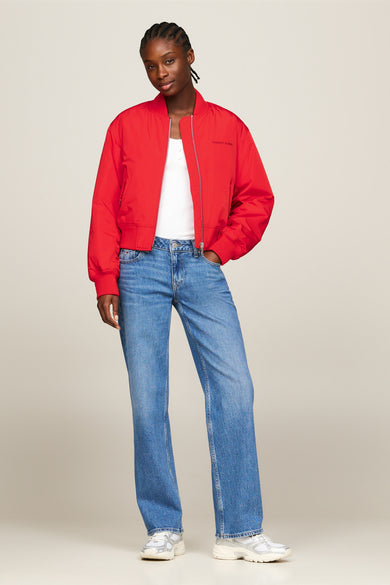 Rode korte jas van Tommy Jeans met een rits en een recht model, gecombineerd met een witte top en blauwe jeans.
