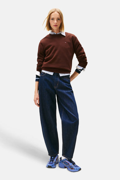 Bruine sweater van TOMMY JEANS, gestyled met een gestreept overhemd en wijde, donkerblauwe jeans met blauwe sneakers.