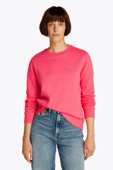 Gilet rose de TOMMY JEANS, porté avec un jean, avec un petit logo sur la poitrine.