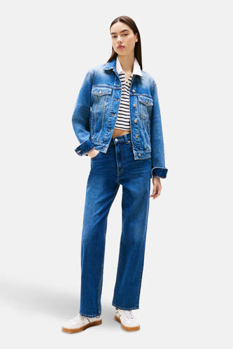 Jean droit bleu marine de TOMMY JEANS, associé à une chemise rayée et un blouson en cuir.