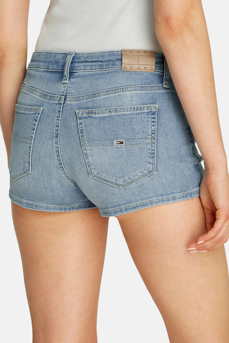 Lichtblauwe denim short van TOMMY JEANS, met achterzakken en een beige leren merklabel.

