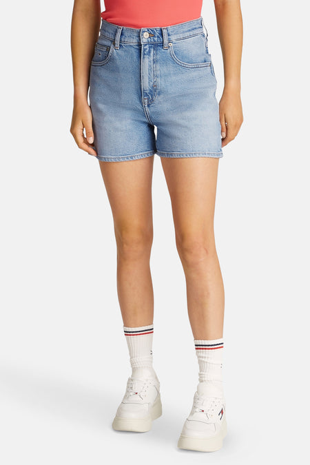 Lichtblauwe denim short van TOMMY JEANS, gestyled met witte sokken en sneakers.