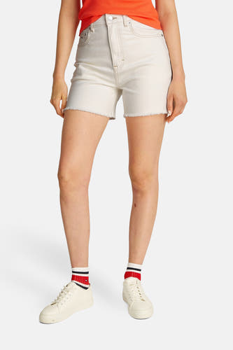 Shorts en denim blanc de TOMMY JEANS, avec un bord froncé, associés à des sneakers blanches et des chaussettes rayées.