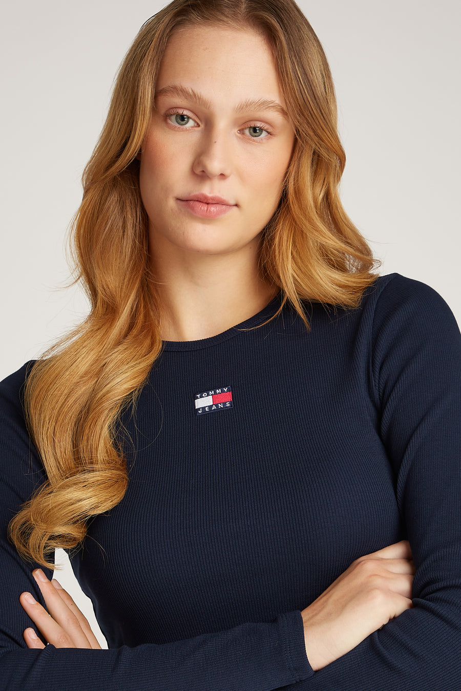 Blauw T-shirt met lange mouwen van TOMMY JEANS, met logo op de borst en gekruiste armen.
