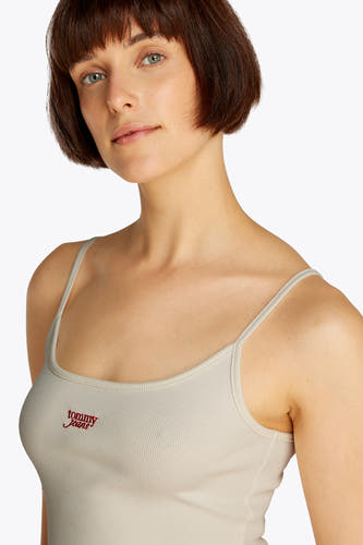 Ecru tanktop van TOMMY JEANS met dunne bandjes en een rood logo op de borst.
