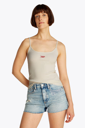 Ecru tanktop van TOMMY JEANS, geribbelde textuur, met spaghettibandjes, gecombineerd met blauwe denim shorts.
