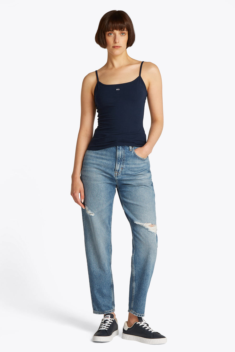 Blauwe singlet van TOMMY JEANS, gedragen met een ripped jeans en donkere sneakers.
