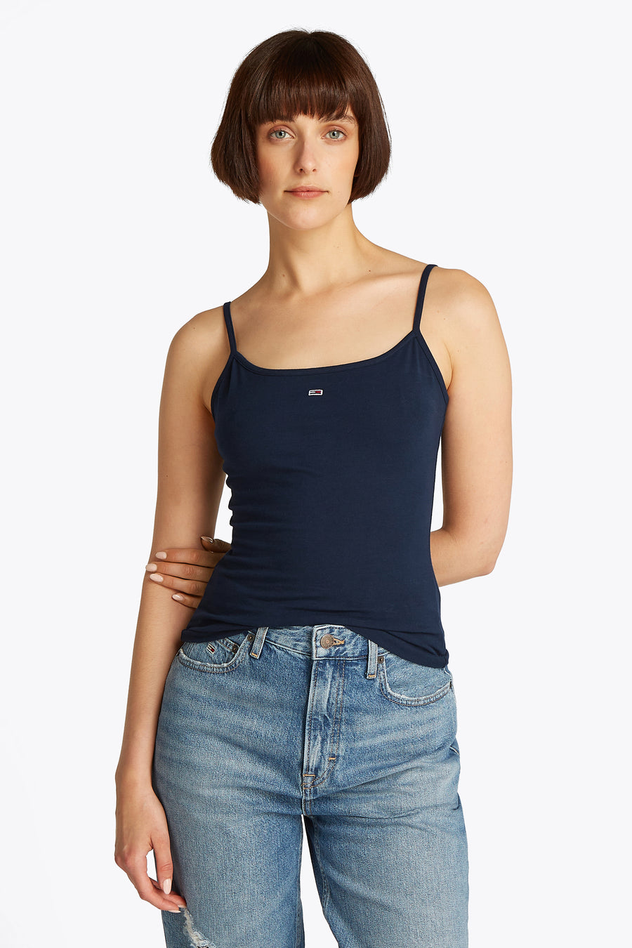 Blauwe singlet van TOMMY JEANS, gedragen met een denim jeans en een bobkapsel.