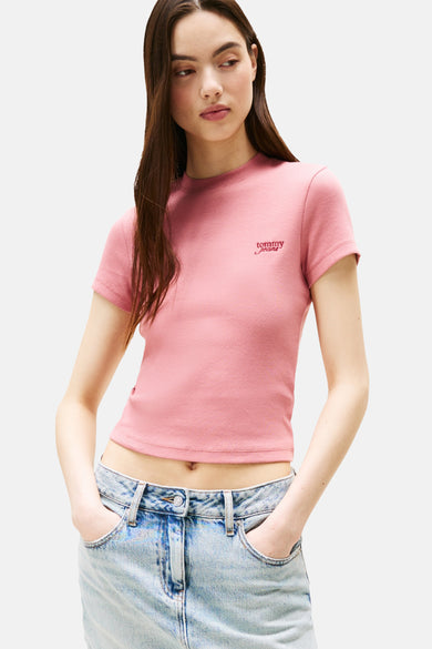 T-shirt rose à manches courtes de Tommy Jeans, texture froissée, porté avec un jean bleu.