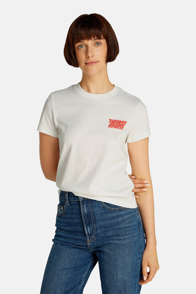 Wit T-shirt met korte mouwen van TOMMY JEANS, met rood logo linksvoor en gecombineerd met blauwe jeans.
