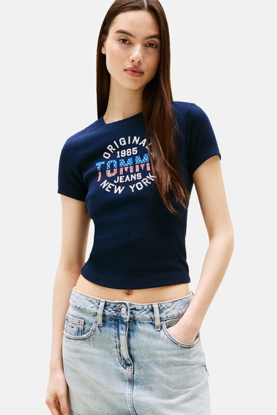 T-shirt bleu marine à manches courtes de TOMMY JEANS, avec une impression ronde et associé à un pantalon en denim.