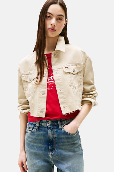 Beige korte jas van TOMMY JEANS, gedragen met een rood T-shirt en blauwe jeans.