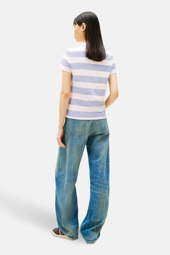 Multicolor T-shirt met korte mouwen van TOMMY JEANS, met een gestreept patroon en gedragen met wijde jeans en sneakers.