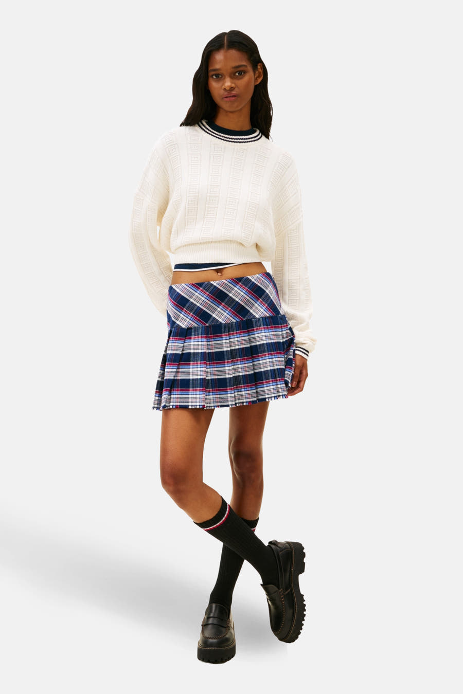 T-shirt blanc avec col rond de TOMMY JEANS, à côtes et porté avec un minirok à carreaux et des chaussettes noires.