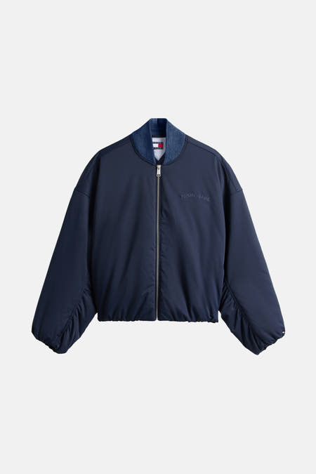 Blauwe jas van TOMMY JEANS met rits en logo op de voorkant.
